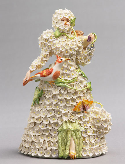 A porcelain figurine of a woman being choked by ornate flowers, by Shary Boyle.