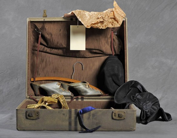 Open suitcase with black hat and blue shoes.