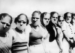 Contestants of the Miss Lovely Eyes competitition wear disturbing face masks, 1930.