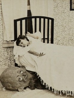 Image of a scary goblin creature peeking out from under the bed of a little girl